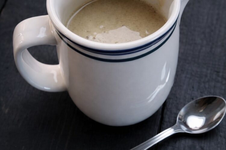 Hausgemachte Vanillesoße vegan serviert im weißen Kännchen