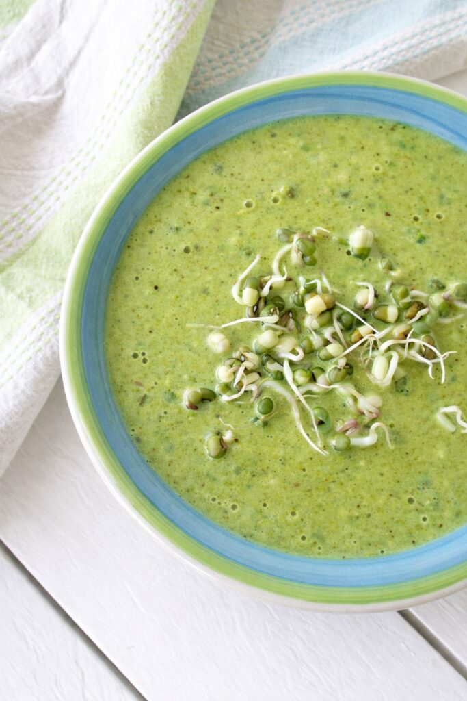 Curried cauliflower soup in a bowl topped with mung bean sprouts