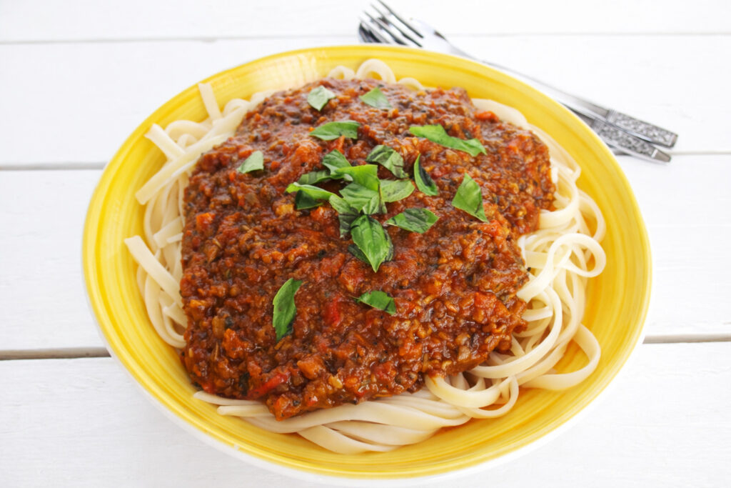 Gluten-free savory Bolognese-style sauce with mushrooms, served with pasta.
