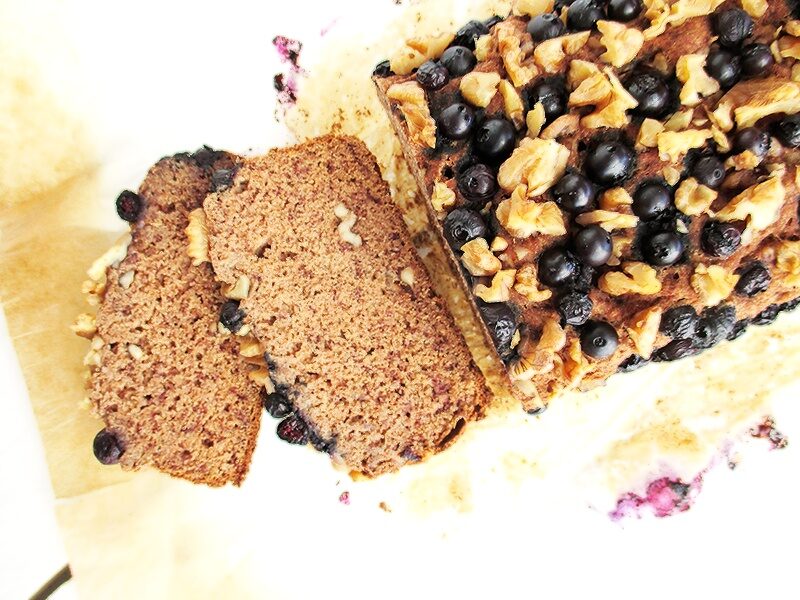 Sliced vegan gluten-free blueberry walnut banana loaf showing a moist crumb