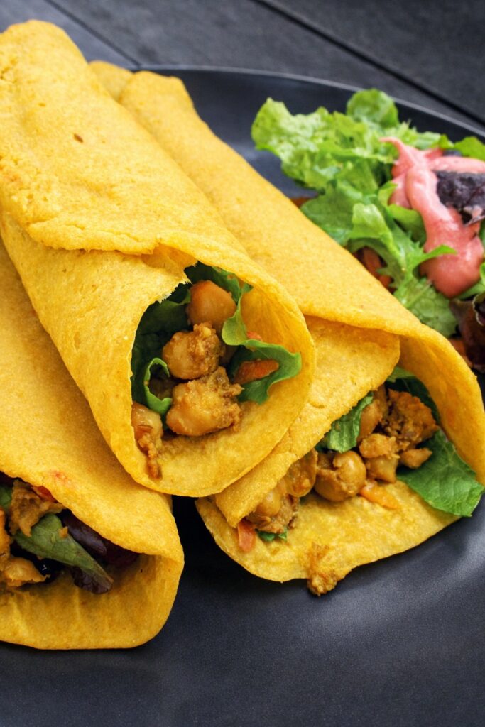 Vegan gluten-free pumpkin wraps filled with spiced chickpeas on a grey plate