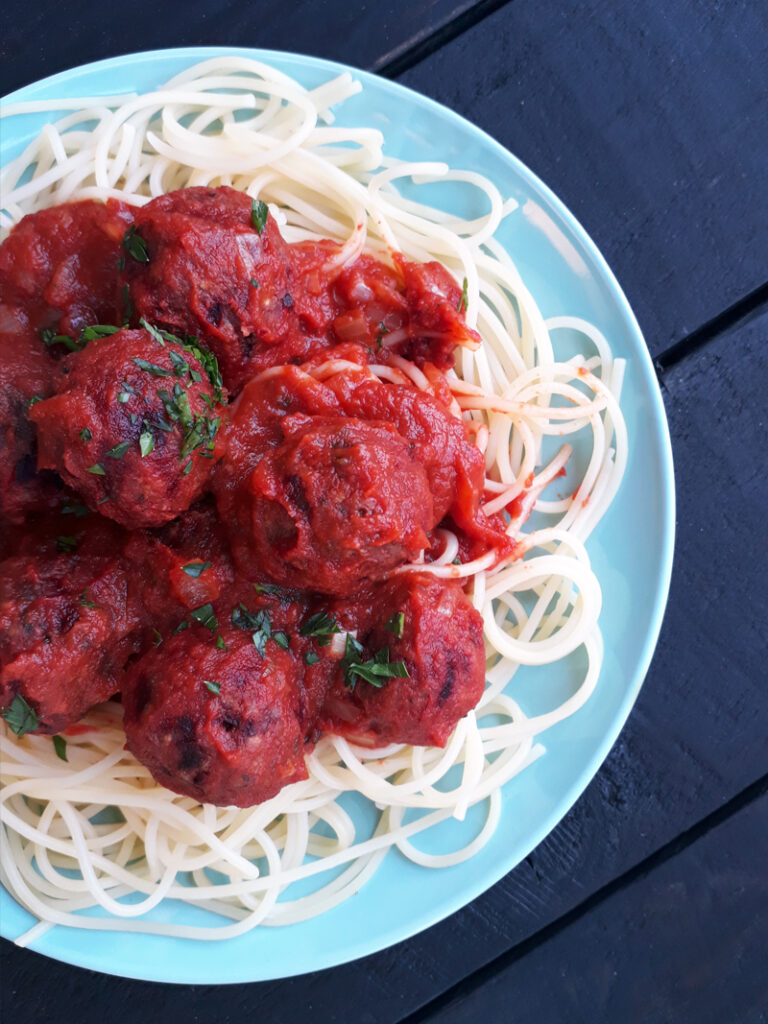 Vegane und glutenfreie Fleischbällchen aus Buchweizen und Roter Bete in Tomatensauce auf Spaghetti serviert